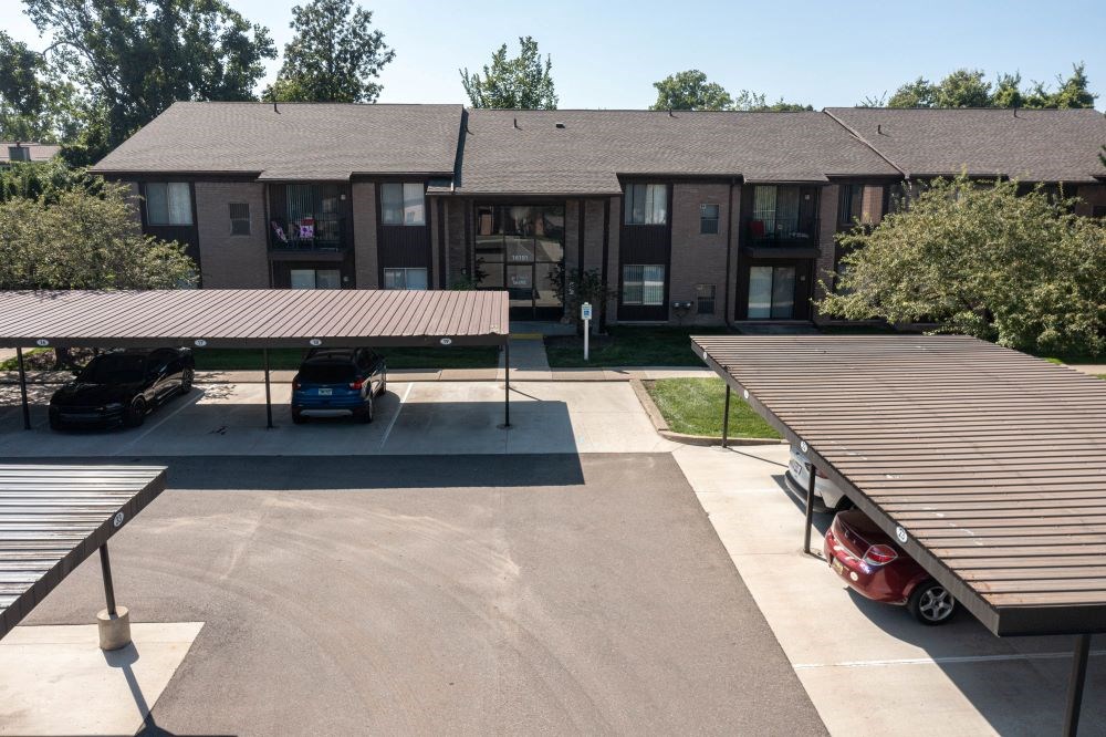 an aerial view of an apartment building with a parking lot